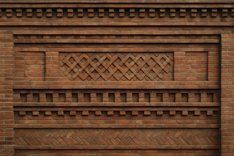 Vue en gros plan d'une façade en brique montrant des motifs complexes et la texture.